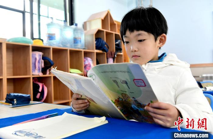 3月14日，西藏拉薩市第一小學(xué)一年級六班學(xué)生丁增樂吉在閱讀藏語課本。　李林 攝