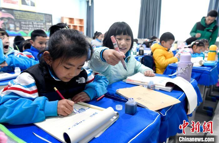 3月14日，西藏拉薩市第一小學(xué)一年級六班學(xué)生白瑪朗珍(圖左)在藏語文課上書寫藏文?！±盍?攝