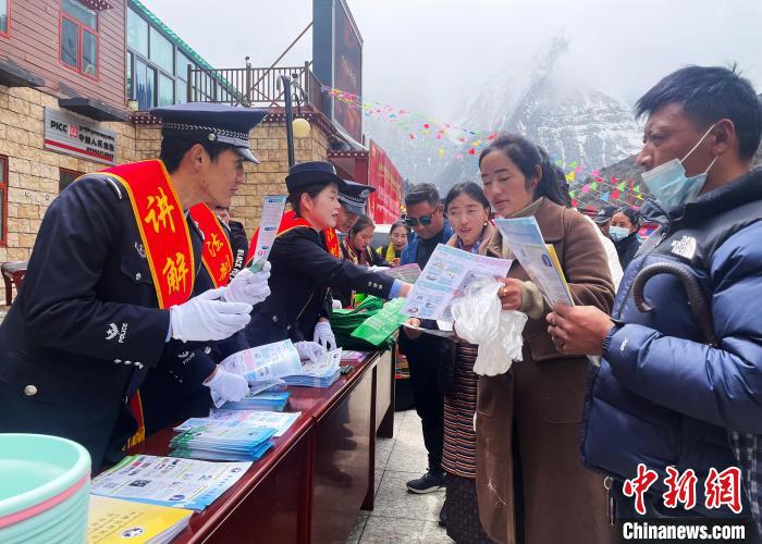圖為山南玉麥邊境派出所民警為轄區(qū)群眾發(fā)放法律知識(shí)宣傳單?！＄婗?　攝