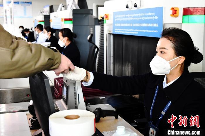 圖為機(jī)場(chǎng)工作人員為旅客辦理行李托運(yùn)。　周航 攝