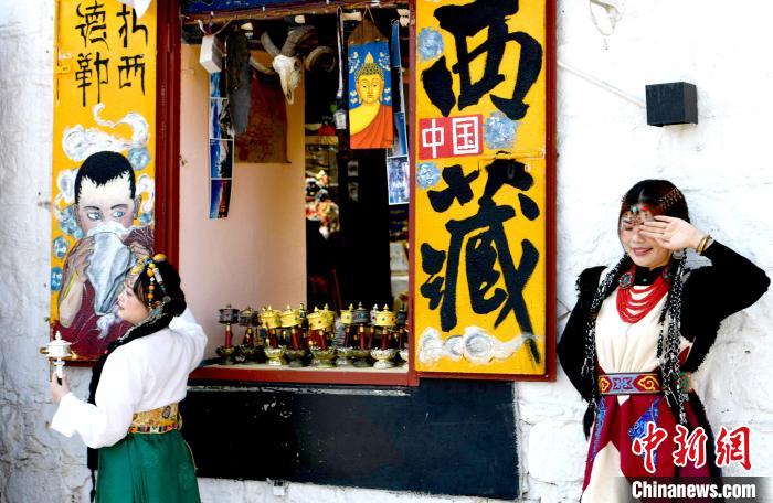4月17日，游客身著藏式元素服裝在拉薩八廓街拍照留念?！±盍?攝