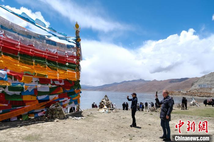 進(jìn)藏參訪嘉賓在羊湖畔拍攝經(jīng)幡?！〗w波 攝