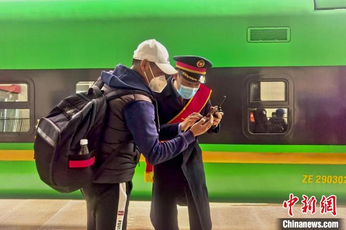 圖為日喀則火車站工作人員服務(wù)乘客。　斗山得 攝