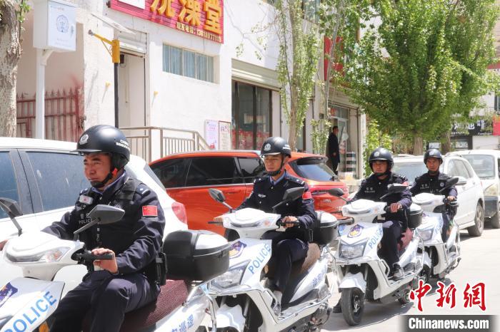 民警騎著電瓶車在轄區(qū)巡邏走訪。　黃創(chuàng)偉 攝