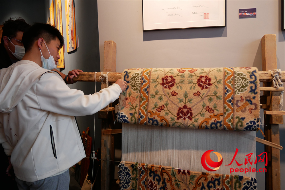 觀眾正在觀賞展出的藏毯。人民網(wǎng) 韋衍行攝