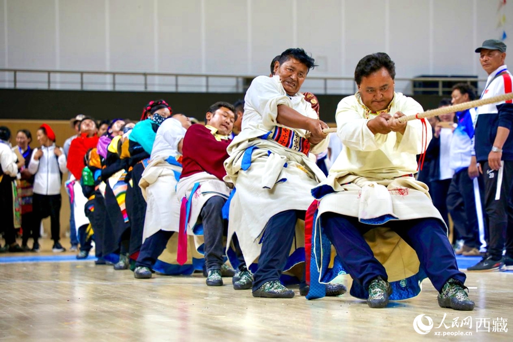 身著民族服裝的農(nóng)牧民選手在拔河比賽現(xiàn)場。