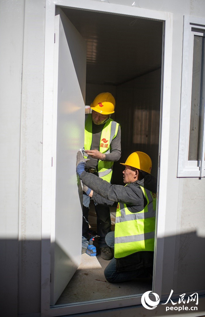 1月9日，在日喀則市定日縣長所鄉(xiāng)古榮村安置點(diǎn)，施工人員正在抓緊搭建移動(dòng)板房，確保受災(zāi)群眾溫暖過冬。人民網(wǎng)記者 翁奇羽攝