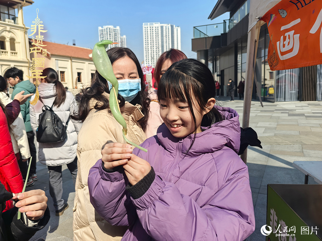 2025年1月29日，湖北武漢的新春廟會上，小朋友拿著吹制好的糖人，十分開心。人民網(wǎng)記者 張沛攝