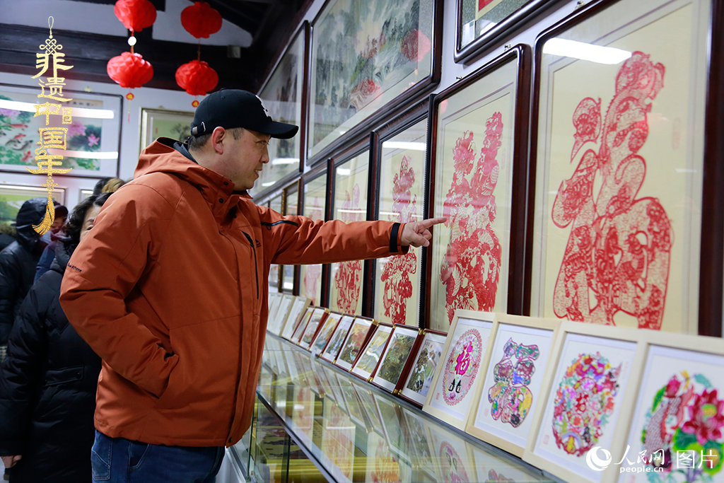 2025年1月23日，游客在天津楊柳青古鎮(zhèn)欣賞傳統(tǒng)剪紙作品，感受指尖上的古老藝術(shù)。人民網(wǎng)記者 崔新耀攝